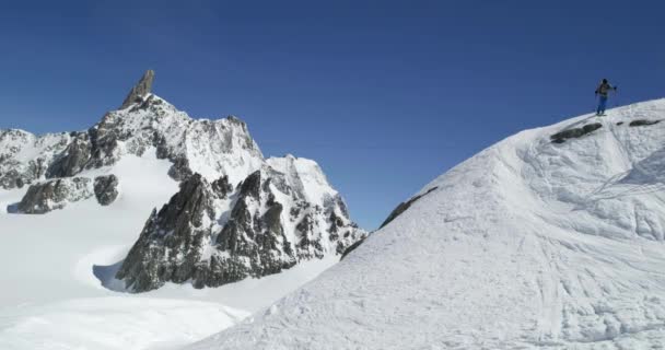 晴れた日の雪に覆われた山の尾根下スキー男フリーライド。登山スキー活動。スキーヤーの人々 の冬の雪のアルペン山屋外スポーツします。正面から見た図。スローモーション 60 p 4 k ビデオ — ストック動画