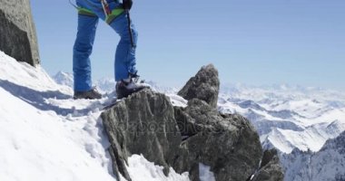 Güneşli bir günde buz baltası ile karlı Dağı üst ulaşan climber dağcı erkeği. Dağcılık Kayak etkinliği. Kayakçı insanlar kış kar spor Alp dağ açık. Arkadan Görünüm. Ağır çekim 60p 4 k video