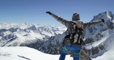 Climber dağcı erkeği karlı Dağı en iyi başarı güneşli günde ulaşan. Dağcılık Kayak etkinliği. Kayakçı insanlar kış kar spor Alp dağ açık. Arkadan Görünüm. Ağır çekim 60p 4 k video