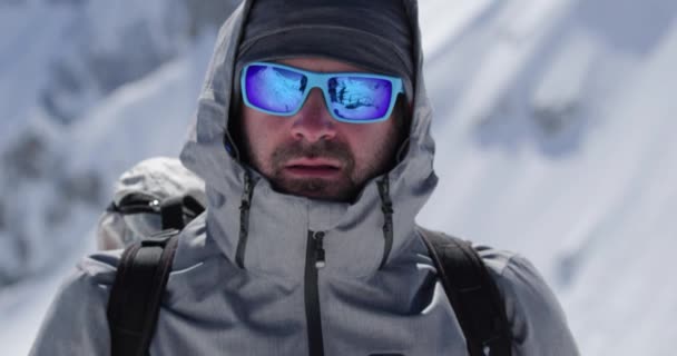 Climber mountaineer man portrait on snowy mount top in sunny day.Mountaineering ski activity. Skier people winter snow sport in alpine mountain outdoor.Front view.Slow motion 60p 4k video — Stock Video