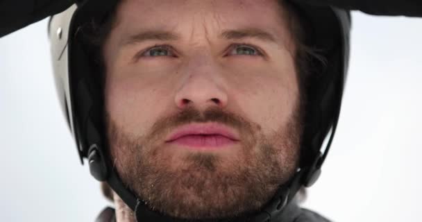 Человек лицом корректирует шлем, готовясь к катанию на лыжах. Лыжники зимний вид спорта в альпийских горах на открытом воздухе. — стоковое видео