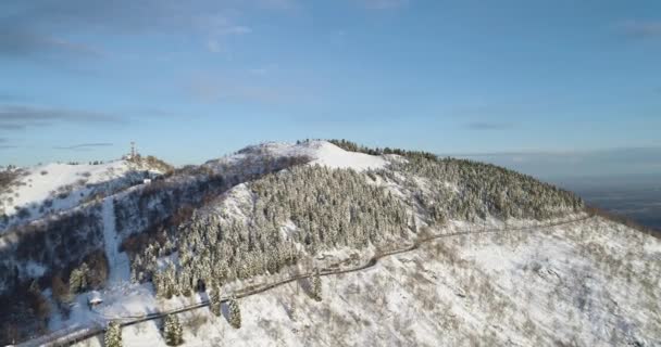 Forward aerial top view on white snow mountain valley in winter.Forest woods.Snowy mountains street path establish isher.Sunset or sunrise sun backlit.4k drone flight straight-down establishing shot — стоковое видео