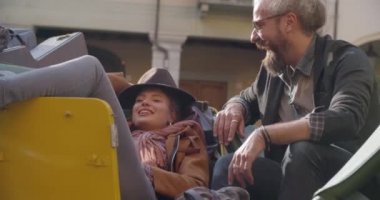 Erkek ve kadın ile gülümseyen güneş gözlüğü, rahatlatıcı ve konuşmaya liying durdurulan araç üzerinde oturmuş. Side.Caucasian kaç aşk roadtrip tatil İtalyan seyahat Cabrio vintage car.4k el video içinde