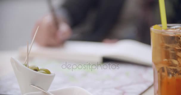 Женщина разговаривает с зеленой оливкой во время коктейльного аперитива возле кафе. Кавказская пара влюблена в путешествие по дорогам Италии — стоковое видео