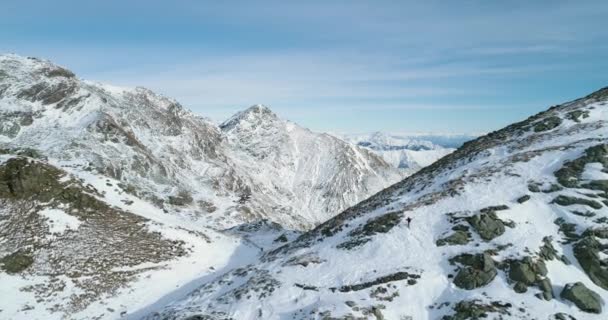 在冬季白雪皑皑的山路上向前飞行的登山滑雪者攀登. 冰雪覆盖了山顶和冰川。冬季野外自然户外制订. 4 k 无人机飞行 — 图库视频影像