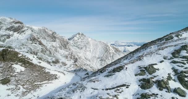 Forward aerial over winter snowy mountain pass with mountaineering skier people walking up climbing.snow covered mountains top and ice glacier.Winter wild nature outdoor establisher.4k drone flight — Stock Video