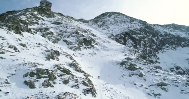 Framåt Flygfoto över snöiga Vinterberg med bergsklättring skidåkare människor gå upp climbing.snow berg topp och is glaciär. Vinter vilda naturen utomhus establisher.4k drone flyg — Stockvideo