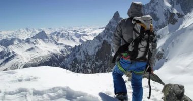 Climber dağcı erkeği karlı Dağı en iyi başarı güneşli günde ulaşan. Dağcılık Kayak etkinliği. Kayakçı insanlar kış kar spor Alp dağ açık. Arkadan Görünüm. Ağır çekim 60p 4 k video