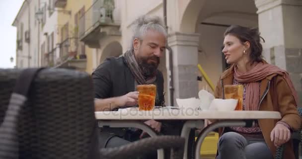 Γυναίκα και άνδρα μιλάμε έχοντας κοκτέιλ, απεριτίφ τοστ έξω από την καφετέρια. Μεσαίο πλάνο. Καυκάσιος ζευγάρι στην αγάπη roadtrip παραθεριστικές κατοικίες ιταλική ταξίδια σε vintage Αυτοκινήτου Τύπου Κάμπριο — Αρχείο Βίντεο