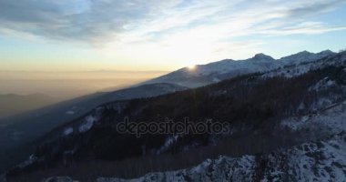 Hava üstten görünüm kış karlı dağ ve orman orman üzerinde gündoğumu veya günbatımı ileri. Kar mavi saat alacakaranlık veya şafak alacakaranlık Alps dağlar sezon establisher.4k drone uçuş atış kurulması