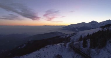 Hava üstten görünüm kış karlı dağ yolu üzerinden iletmek. Atış kurmak mavi saat alacakaranlık veya şafak alacakaranlık Alps dağlar sokak yol kar establisher.4k drone uçuş