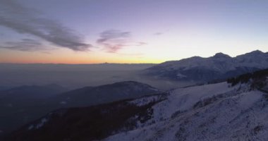 Kış karlı dağ yolda seyahat araba ile üzerinden geriye doğru hava üstten görünüm. Atış kurmak mavi saat alacakaranlık veya şafak alacakaranlık Alps dağlar sokak yol kar establisher.4k drone uçuş