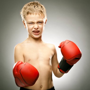 Genç kızgın çocuk oyun kutusu used eldiven portre ile gri arka plan üzerinde