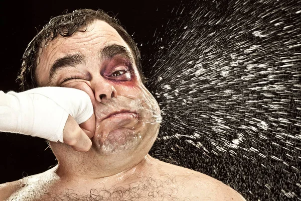 Боксер с синяком на глазу плюнул из-за большого удара. — стоковое фото