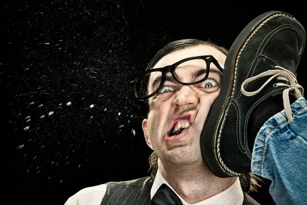 Elegant nerd with glasses hit by kick on black background — Stock Photo, Image