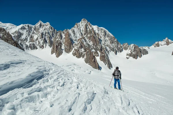 Skier man exploring glacier or snowy land walking with snowshoes or alpine ski. Europe Alps Mont Blanc massif mount. Winter sunny day, snow. Wide long shot — Stock Photo, Image