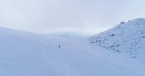 冬雪の山スキー トラック フィールド上登って登って登山スキーヤー人々 と空中を軌道します。雪を覆った山。霧の雲が上昇します。冬自然アウトドア スポーツ establisher.4k ドローン — ストック動画