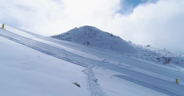 Framåt Flygfoto över vintern snowy mountain ski spår fältet. Solig dag, dimmigt moln. Dimman stiger. Alperna berg snö säsong establisher.4k drone flyg idrott skott — Stockvideo