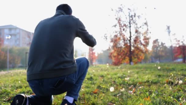 Liten flicka kör till pappa och krama honom på urbana stadspark i höst. Far kramas rinnande dotter utomhus tillsammans. Solnedgång, bakgrundsbelyst. Samhörighet, familj och barndom concept.4k handhållna video skott — Stockvideo