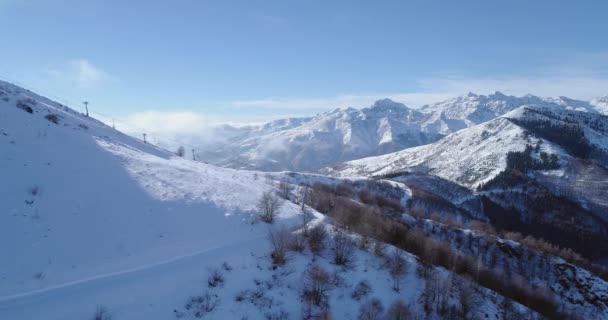 Aérien latéral sur neige blanche pic de montagne en hiver révélant télésiège skieur. Forêt woods.Snowy montagnes Establisher avec soleil rétroéclairé. Alps.4k vol de drone italien établissant tir — Video