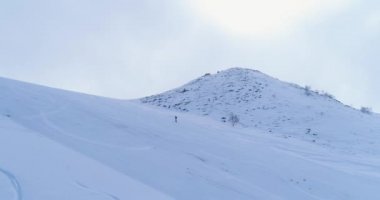 Yan hava kış karlı dağ Kayak Atletizm tırmanma kadar yürüyüş dağcılık kayakçı insanlar üzerinde. Kar dağların kaplı. Yükselen sis bulutları. Kış Doğa açık spor establisher.4k dron