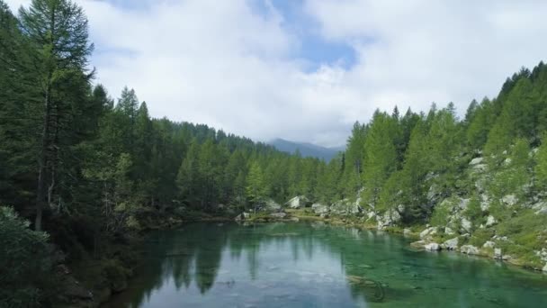 空中向前越过蓝色高山湖泊, 揭示山森林山谷在阳光明媚的夏天与云。欧洲阿尔卑斯山户外绿色自然景观山野制订者. 4 k 无人机飞行建立射击 — 图库视频影像