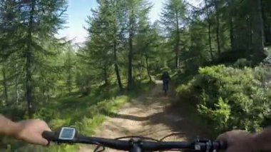E-bisiklet sürme Pov adam arkadaş kadını takip. Mtb eylem bisikletçi iz yolu forest yakınındaki birlikte keşfetme eylemi. Elektrikli bisiklet için etkin olan kişileri spor seyahat tatil İtalya Alpleri'nde summer.4k video açık havada