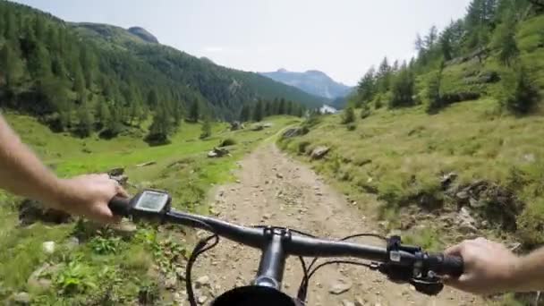 POV man riding e-bike on downhill near lake.Mtb action cyclist exploring trail path near mountains.Electrical bike active people sport travel vacation in Europe Italy Alps outdoors in summer.4k video — Stock Video