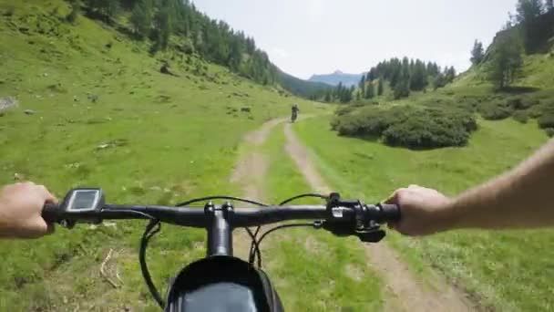 POV man riding e-bike following friend woman.Mtb action cyclist exploring together mountain trail path.Electrical bike active people sport travel vacation in Italy Alps outdoors in summer.4k video — Stock Video
