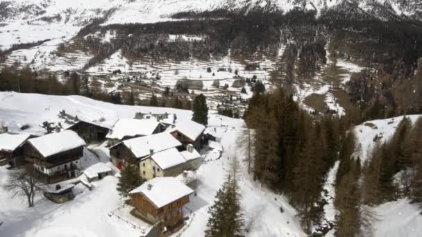 在阳光明媚的冬日空中飞越雪地木屋村舍 — 图库视频影像