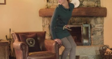 Oturma odasında genç ve çekici bir kadın. Gündüz vakti lüks bir otel odasında koltukta dinlenen bir kadın. Koltukta oturan ve evinde dinlenen bir kadın. Koltuğunda rahat bir kadın