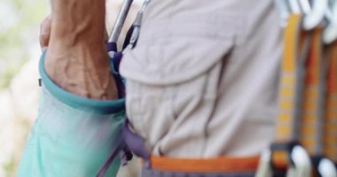 Dağcı adam tebeşir tozu alarak kayalık duvar yarığına tırmanmaya hazırlanıyor. Aşırı aktif spor aktivitelerine tırmanıyorum. Aktif insanlar, açık hava aktiviteleri. Toz torbası detayı. Hareketli 4k video.