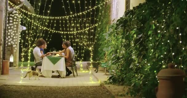 Quattro persone, due coppie felici che parlano e mangiano durante una romantica cena gourmet o pranzo.Luci luminose.Scatto medio. Amici viaggio italiano in Umbria.4k slow motion — Video Stock