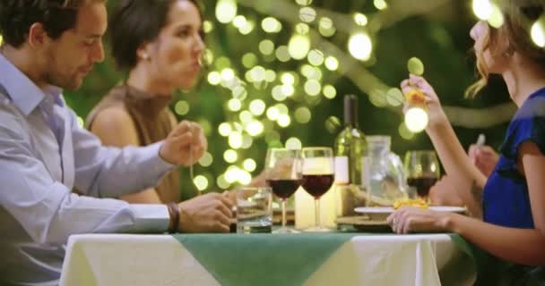 Four people, two couples happy talking and eating during a romantic gourmet dinner or lunch. Approaching wide shot. Поездка друзей в Умбрию. — стоковое видео