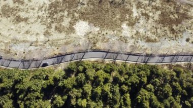 Güneşli bir günde, kış mevsiminde ormanın yanındaki yolda. Kış yolu havası