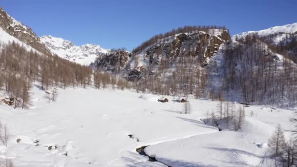 Aérea sobre el país de las maravillas del invierno, valle nevado de la montaña en la escena soleada del invierno day.Winterland con logias y la gente que camina sobre la nieve. — Vídeos de Stock