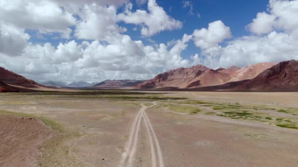 Aérien sur route Sentier de gravier 4x4 sur les montagnes arides et colorées du désert.Pamir Route de la soie voyage aventure dans le désert du Tadjikistan près du lac de Zorkul, Asie Centrale. — Video