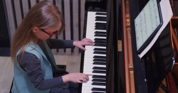 Ragazzo che impara a suonare il pianoforte a casa.Ragazzo che pratica il piano.Vista laterale.Bambina che suona il pianoforte — Video Stock