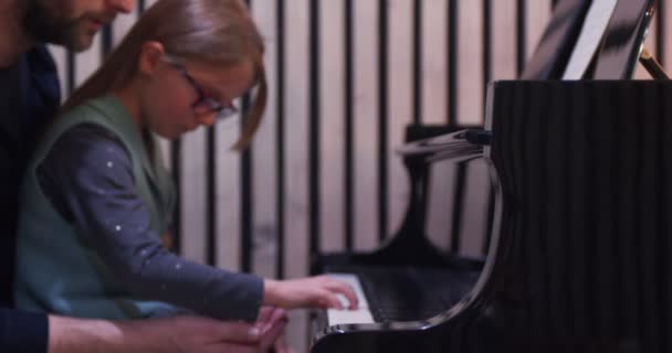 Ο μπαμπάς διδάσκει πιάνο στην κόρη του.Κοριτσάκι μαθαίνει πιάνο στο σπίτι-πλαϊνή όψη.Μάθημα πιάνου στο σπίτι. Παιδί μαθαίνει πιάνο από τον πατέρα της — Αρχείο Βίντεο