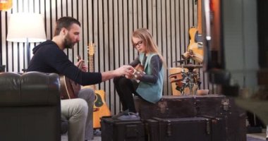 Baba kızına gitar ve ukulele öğretiyor. Küçük kız evde gitar öğreniyor. Ukulele dersi evde. Çocuk babasından gitar öğreniyor.