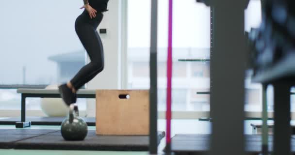 Mujer saltando en la caja en el gimnasio. Entrenamiento piernas de mujer. Vista frontal MS, cámara lenta. Actividad cardiovascular fitness. Entrenamiento de mujer en gimnasio — Vídeos de Stock