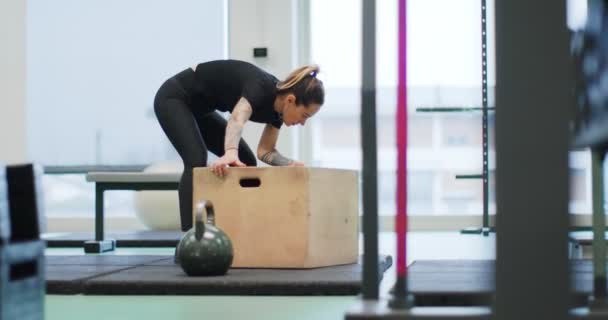 Женщина готовится к прыжкам коробка в гимнастике. Патологоанатом, замедленная съемка. Фитнес-кардио. Женские тренировки в спортзале — стоковое видео