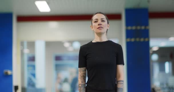 Femme au repos pendant l'entraînement à la gymnase. Femme fatiguée se détendre pendant la pause fitness. Vue de face, plan moyen — Video