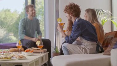 Dört arkadaş konuşmaktan, yemekten ve kokteyl içmekten mutlu. Mutlu insanlar grubu, modern ev partilerinde ya da öğle yemeklerinde eğleniyor.