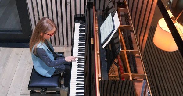 Ragazzo che impara a suonare il pianoforte a casa.Ragazzo che pratica il piano.Vista laterale.Bambina che suona il pianoforte — Foto Stock