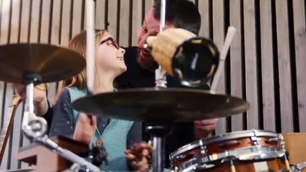 Otec a dcera hrají spolu perkuse. Holčička se učí bubny se svým tátou doma. — Stock video