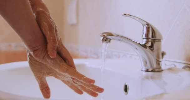 Een vrouw waste haar handen zorgvuldig met water en zeep in de badkamer. Detail van vrouwen handen wassen op wastafel.Slow motion close-up — Stockvideo