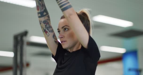 Mulher descansando durante o treino no ginásio.Mulher cansada relaxando durante o intervalo de fitness. Vista frontal, de perto. Mulher aquecendo alongamento — Vídeo de Stock