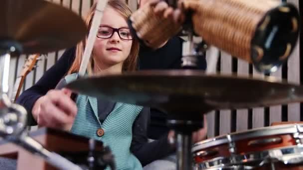 Père et fille jouent ensemble des percussions. Petite fille apprenant la batterie avec son père à la maison. Vue de face gros plan. Cours de percussions à la maison. — Video