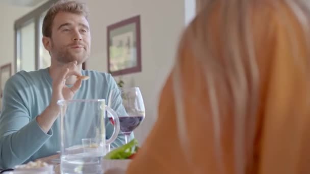 Człowiek rozmawia podczas wspólnego jedzenia posiłku, picia wina.Przyjaciele cieszyć się nowoczesną kolację lub obiad.Handheld wideo — Wideo stockowe